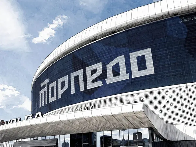 Вид на стадион с вывеской 'TORPEDO' на синем фасаде под голубым небом.
