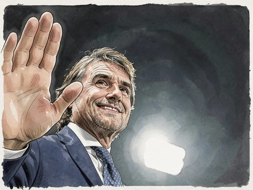 Jim Ratcliffe in blauem Anzug und Krawatte winkt vor dunklem Himmel