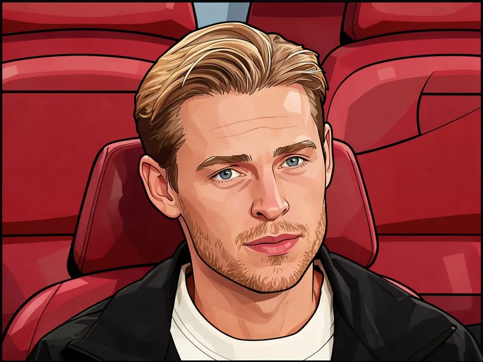 Frenkie de Jong sitzt auf einem Stadionplatz in einer schwarzen Jacke und einem weißen Hemd.