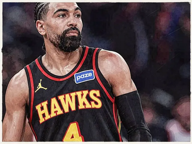 Баскетболист в чёрной форме с надписью HAWKS смотрит в сторону.