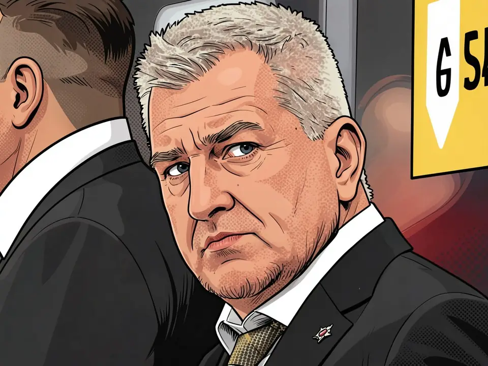 Oleg Bratas, head coach of Admiral, in a suit on the bench after the match.