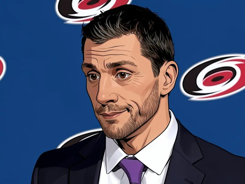 Carolina Hurricanes executive in a suit and purple tie against a blue backdrop with team logos
