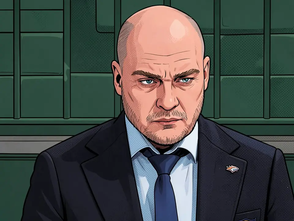Metallurg coach Andrei Rasin after a match, looking serious in a suit.