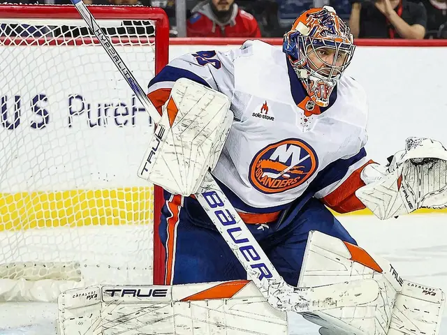 Goalie Vaněček in Islanders gear stands in the net on the ice.