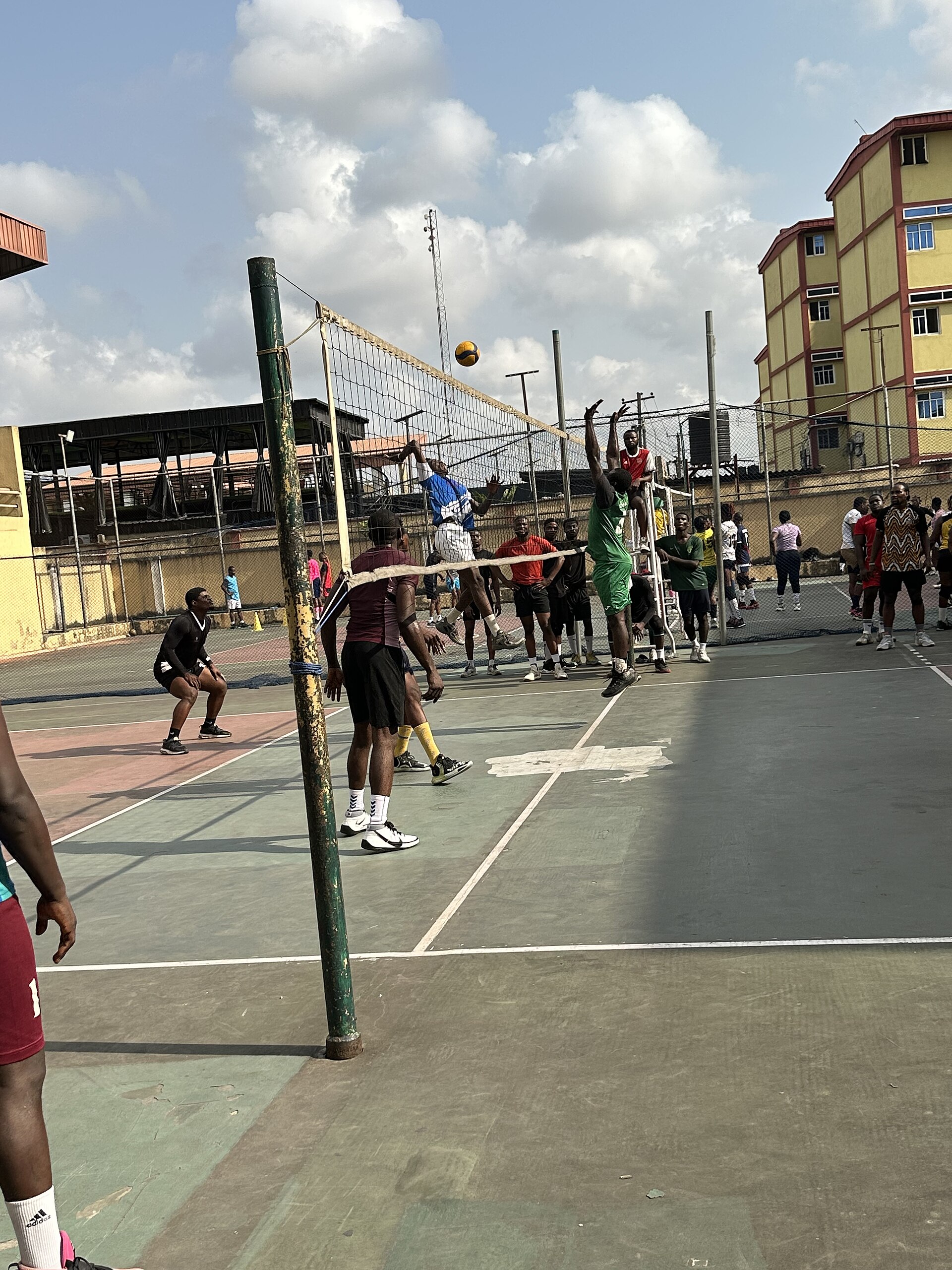 Players competing in an outdoor volleyball match at a private sports court in Lagos