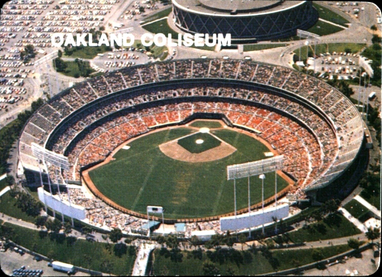 The checklist card of the 1984 Mother's Cookies Oakland Athletics trading cards set. An aerial photograph of the Oakland Coliseum appears on the front of the card and a checklist of all 28 of the trading cards in the set appears on the back. The card is numbered #28 in the set.