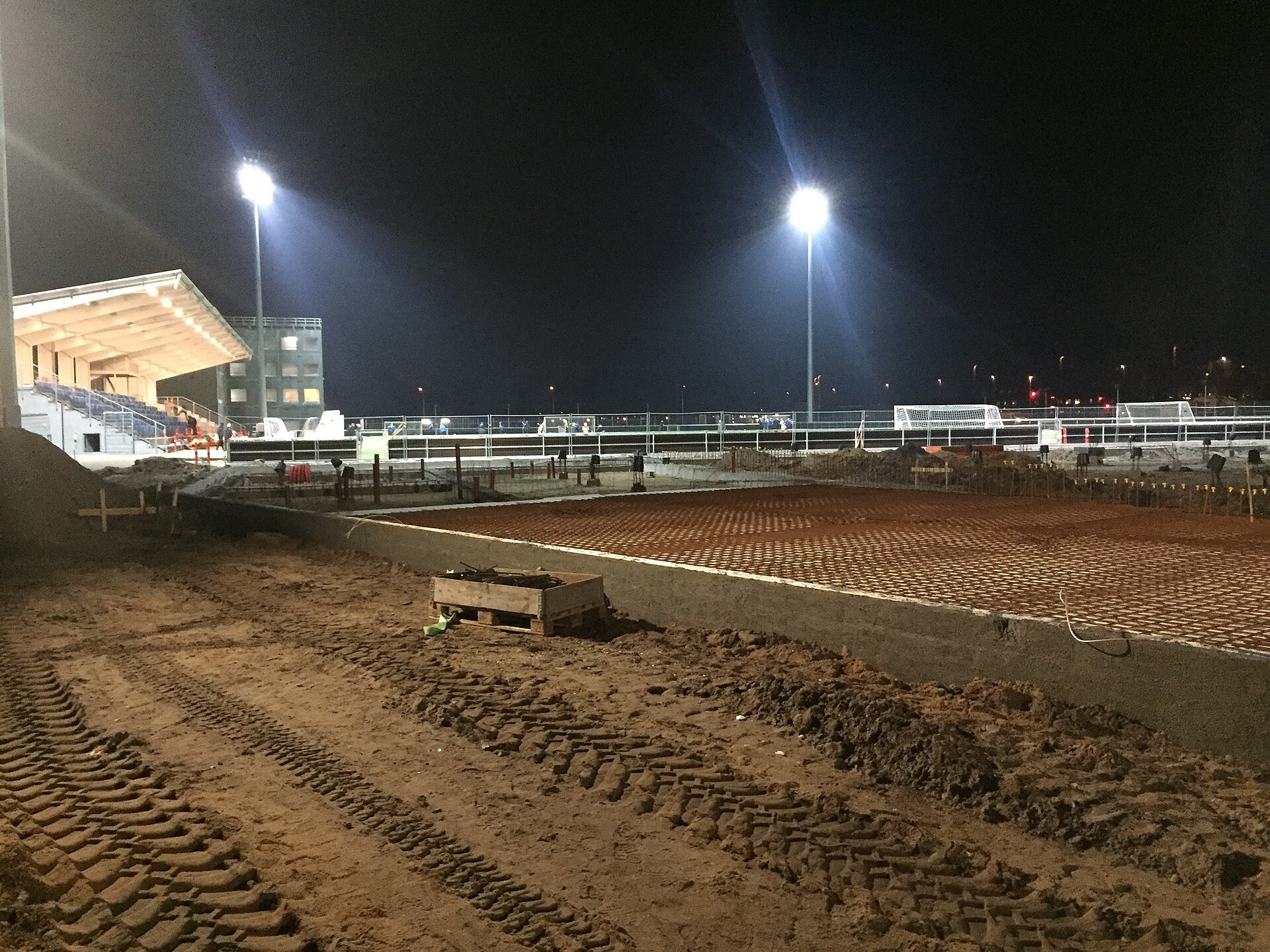 A picture of Køge Stadium at night during the renovation-stage.