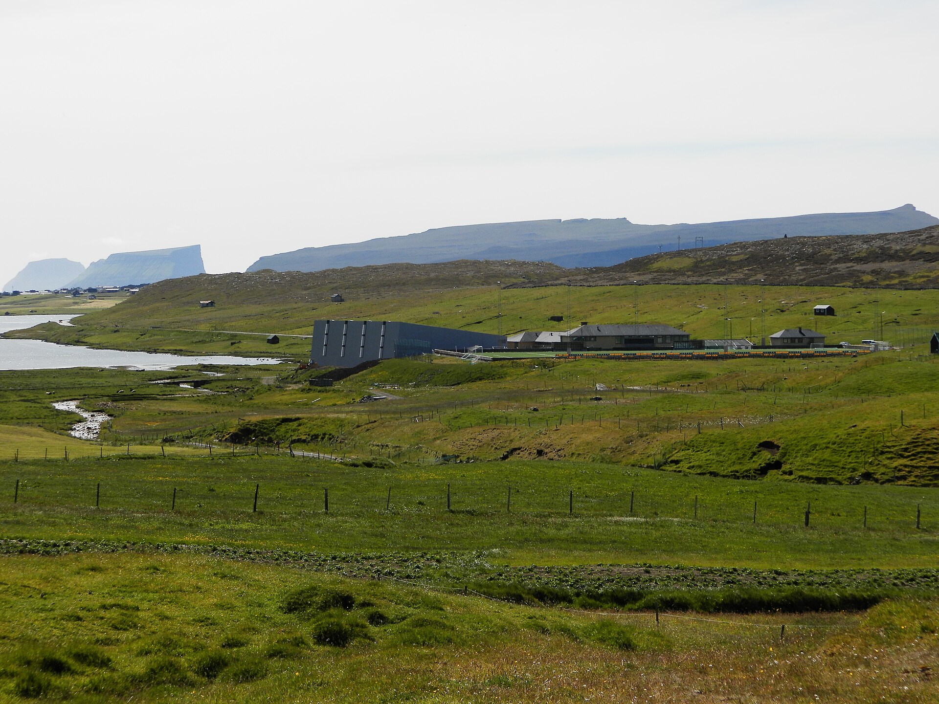 Inni í Dal (in the Valley) on Sandoy, Faroe Islands, is a place where the football stadium of B71 Sandoy is located along with the school and the new sports hall. The school is for children from all of Sandoy island. The lake on this photo is Sandsvatn, which is the largest lake on the island. You c
