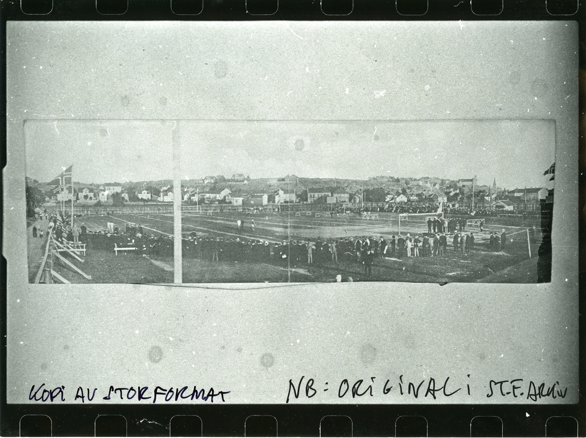 Norwegian championship in athletics on 28-29 September 1915, at the new Fredrikstad Stadium, also called "Mørcheløkka". In the rear, we see some landscapes: St. Hansfjellet - Valhalla on the right (on the mountain), the church tower of Vestre Fredrikstad kirke at the right of Valhalla.
