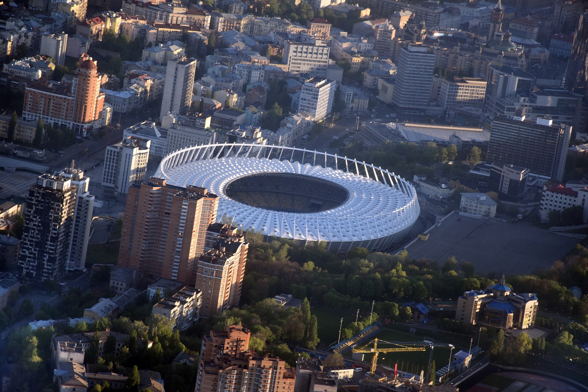 Aerial view of Olimpiyskiy National Sports Complex and buildings of historical neighbourhoods of Kiev — Cherepanova Gora and Nova Zabudova. Velyka Vasylkivska Street is visible on the upper left side of the picture, in the upper centre part (over the stadium) is Esplanadna Street, in the lower left 