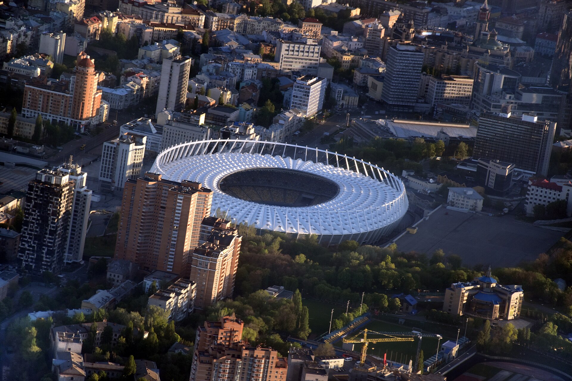 Aerial view of Olimpiyskiy National Sports Complex and buildings of historical neighbourhoods of Kiev — Cherepanova Gora and Nova Zabudova. Velyka Vasylkivska Street is visible on the upper left side of the picture, in the upper centre part (over the stadium) is Esplanadna Street, in the lower left 