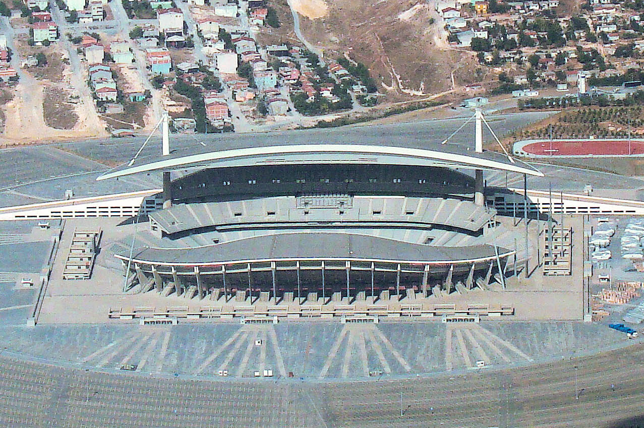 Atatürk Olympic Stadium/Atatürk Olimpiyat Stadı photographed from a north-bound passenger plane shortly after take-off from Atatürk International Airport. Construction of the stadium was completed in 2002, with room for 75,486 people to sit, lots of cars to park and at least three helicopters to lan