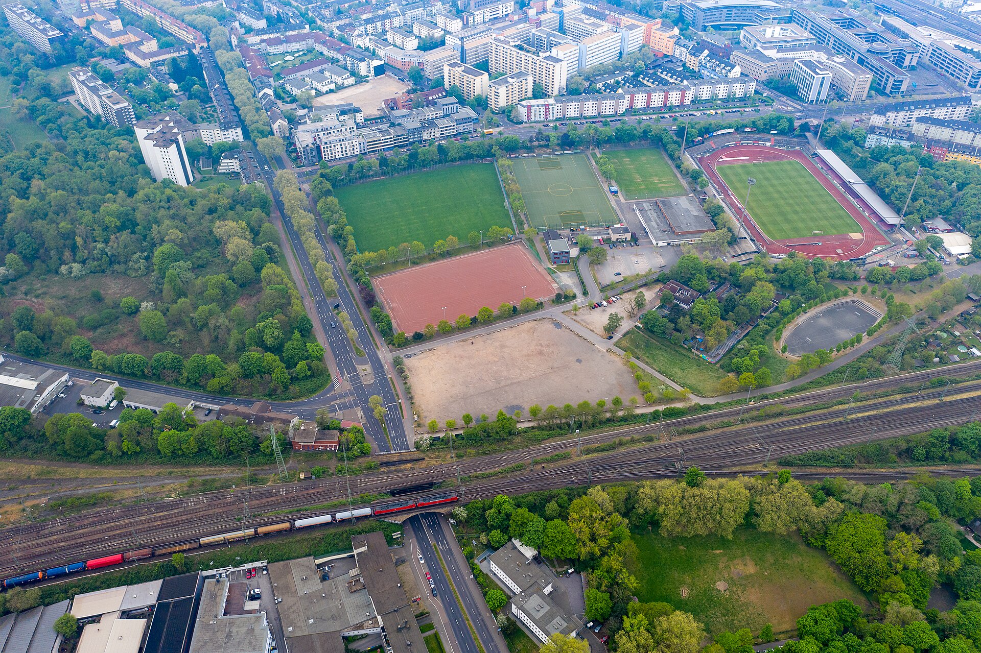 Sportkomplex des Kölner Südstadions, Im Vordergrund die Vorgebirgsstraße mit Zugstrecke und Güterzug