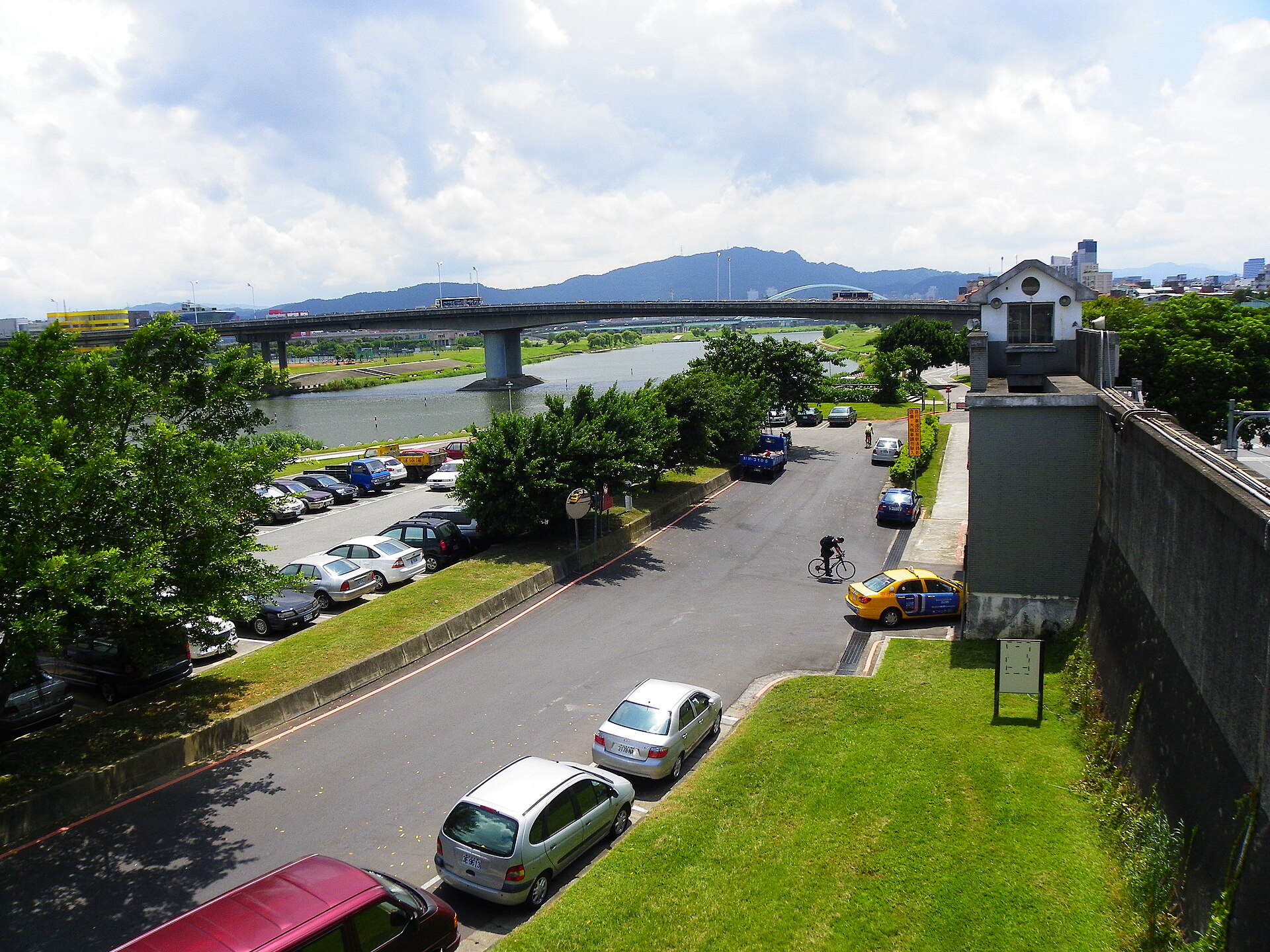 ​從觀山河濱公園河堤自行車道橋頂南望塔悠疏散門與民權大橋西端。