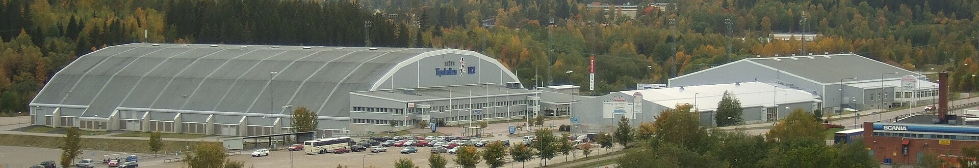 Panoramic view from east-northeast of Gärdehov sports/fair centre, Sundsvall, Sweden. Nordichallen (trade fairs & indoor soccer) to the left, Gärdehallen (ice hockey & figure skating) to the right behind Ungdomshallen (ice hockey & fairs). In the background the lights of the bandy field can be seen.