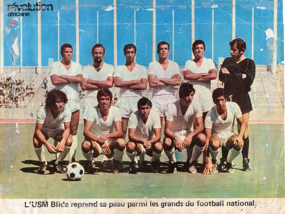 1 er match disputé au stade du 5 juillet en championnat entre l'USM Blida et CR Belcourt (1-0). De gauche à droite : Debout : Amar Amrane - Berrouane - Hmed Benzohra - Rabah Saâdane - Mohamed Amour - Farid Allili (GB). Accroupis :Idries - El Hadi Benturki - Nadhir Kellal - Nasreddine Akli - Mustapha