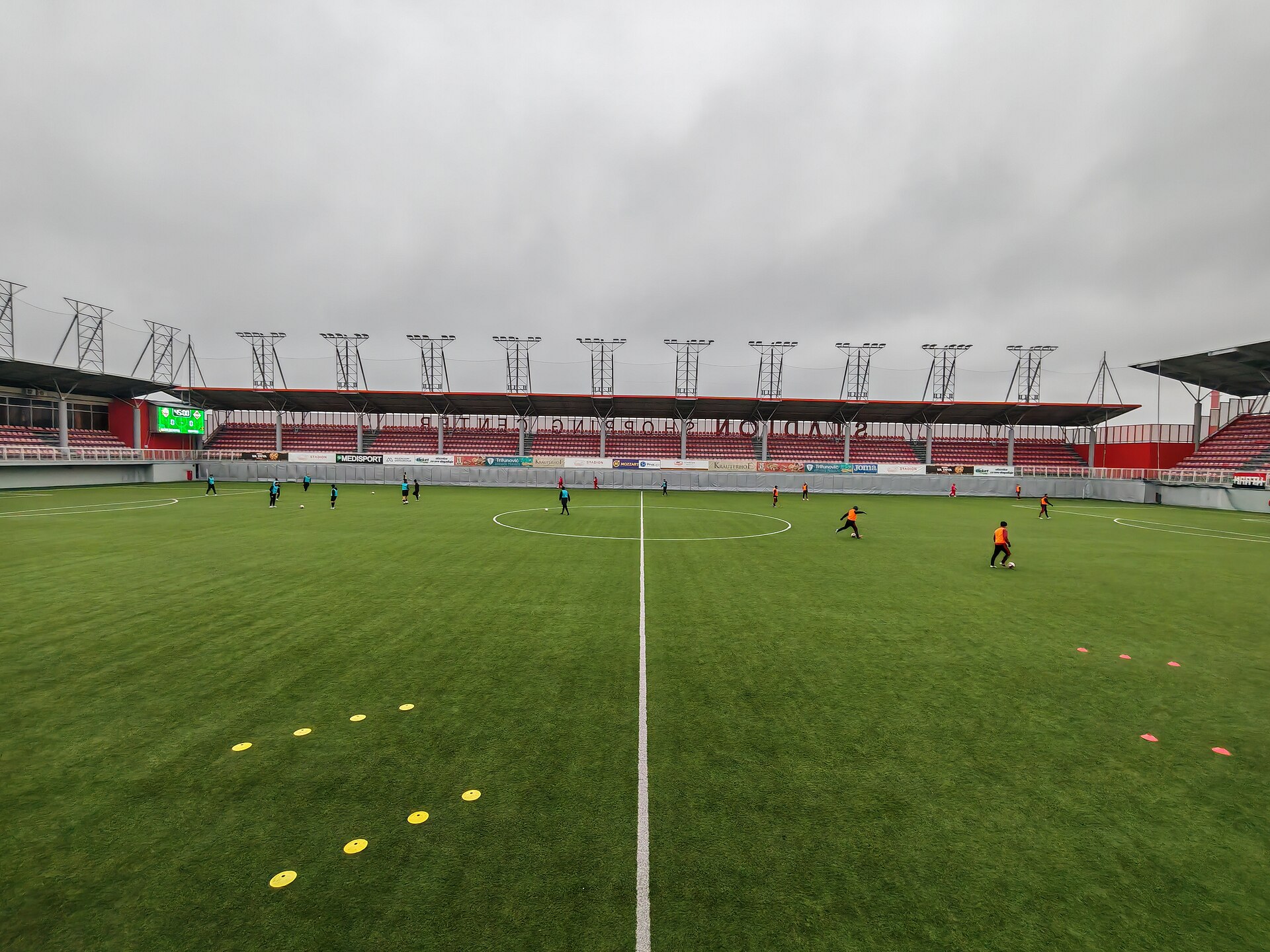 Centered view on the football pitch of Voždovac Stadium from the west stand, February 2026