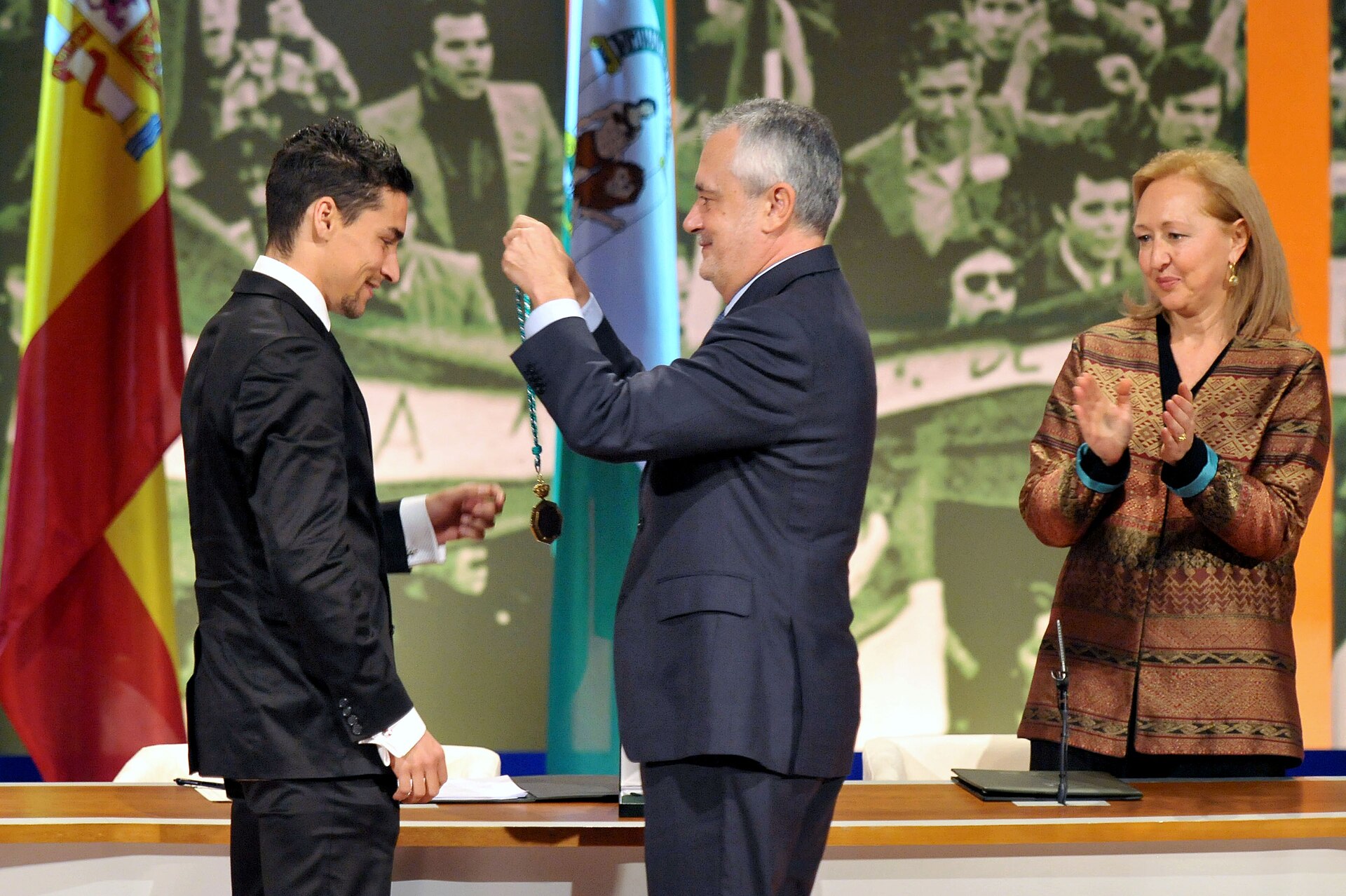 El presidente andaluz, José Antonio Griñán, impone la Medalla de Andalucía al futbolista del Sevilla Fútbol Club Jesús Navas, en presencia de la presidenta del Parlamento, Fuensanta Coves.