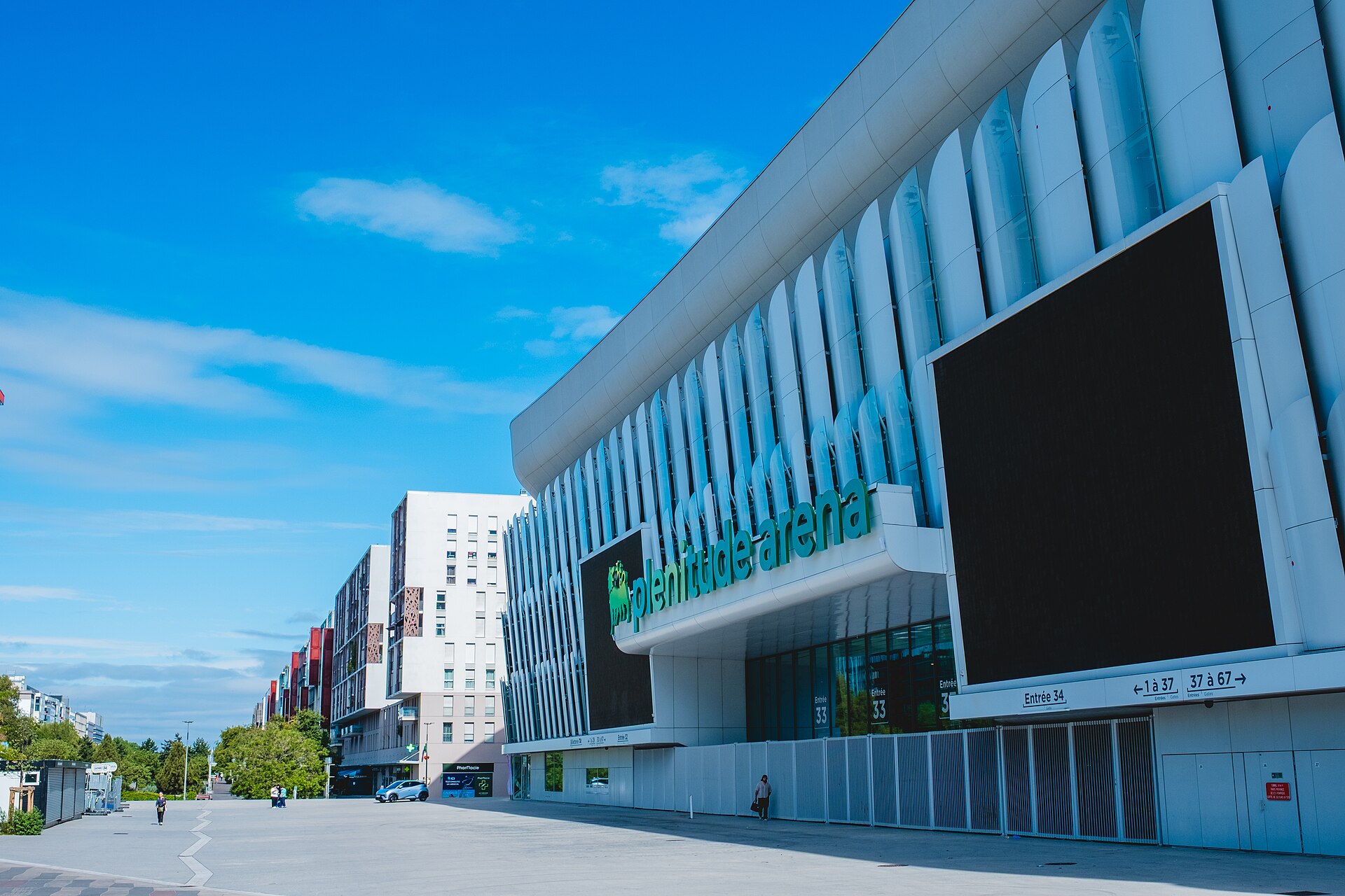 Photo de la façade de la Plenitude Arena avec la nouvelle enseigne naming posée au dessus de la casquette porte 33