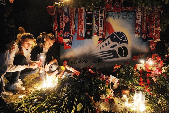 Lighting candles amongst a bed of flowers at the Arena-2000 stadium in Yaroslavl