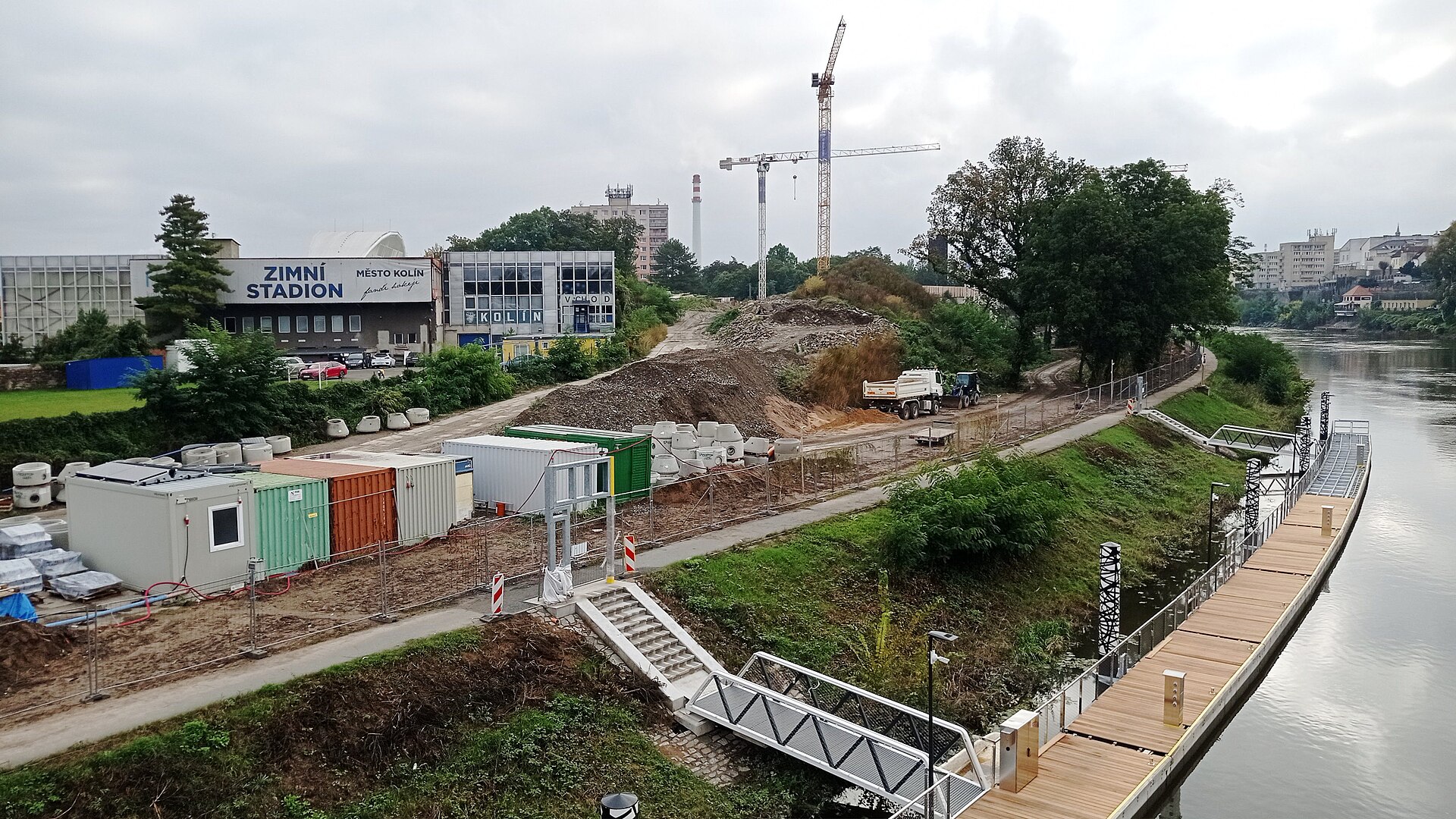 Construction site along the newly-built floating pier along the Elbe in Kolín, Central Bohemian Region, Czechia; in the background: winter stadium