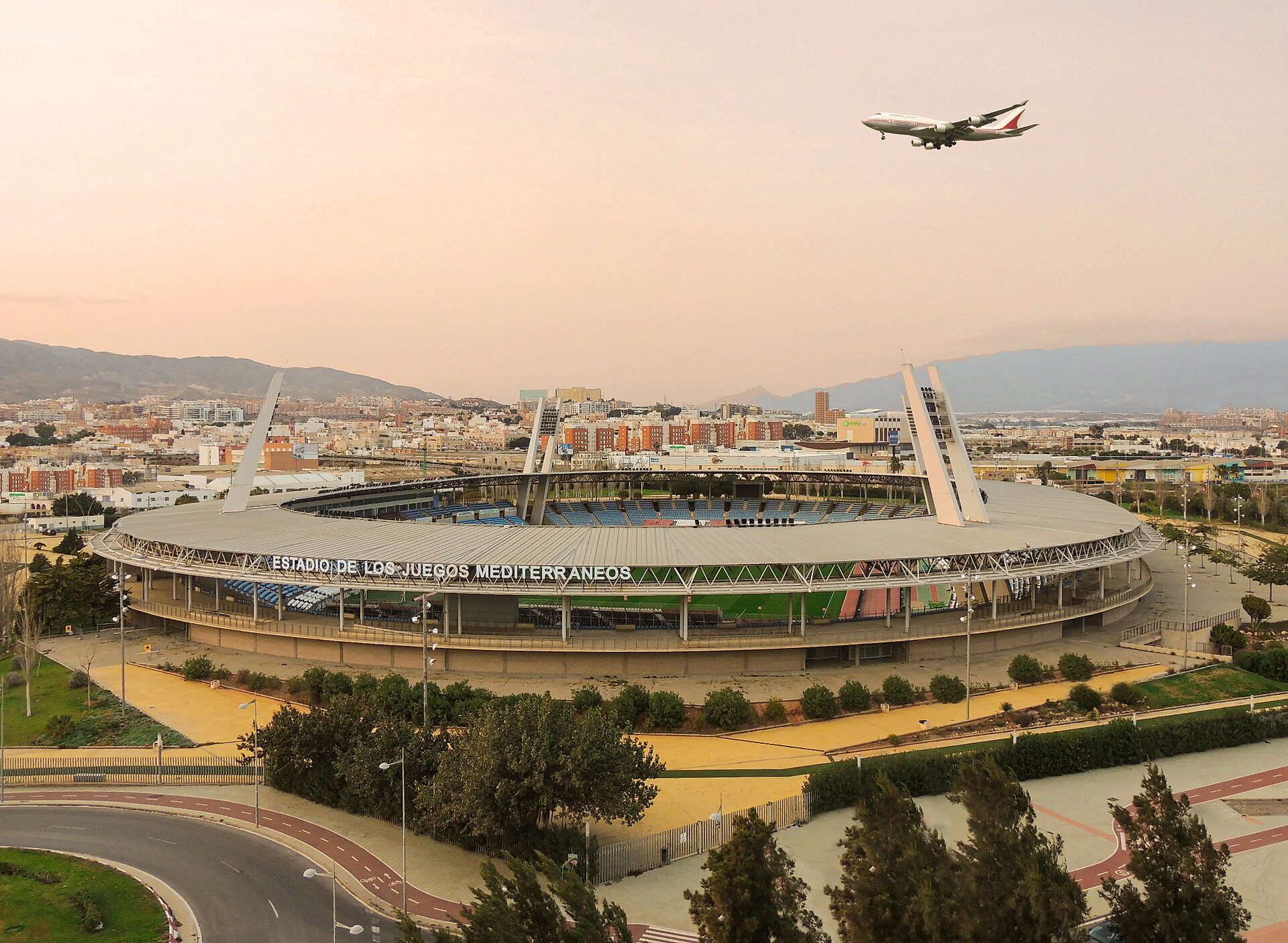 Airplane flying over the Estadio de los Juegos Mediterráneos, Almería, Spain. This is the stadium where UD Almeria plays its home matches