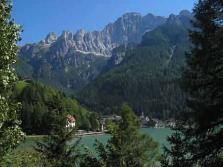 Lago di Alleghe und die Nordwestwand der Civetta. V.l.n.r.: Torre di Coldai (2600 m), Torre di Alleghe (2649 m), Torre di Valgrande (2715 m), Pan di Zucchero (2726 m), Monte Civetta (3220 m), Piccola Civetta (Kleine Civetta) (3207 m) und im Vordergrund Col Roan (2281 m), rechts dahinter die Cima de