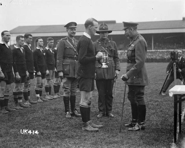 King George V presents a cup to the captain of the winning New Zealand Services Rugby Team, London, Apr 1919. Reference number: 1/2-014210-G 1 b&w original negative(s). Dry plate glass negative 4 x 5 inches. Horizontal image. Part of Royal New Zealand Returned and Services’ Association: New Zealand